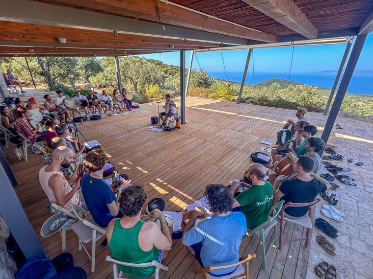The whole group playing under the pergola, the sea behind