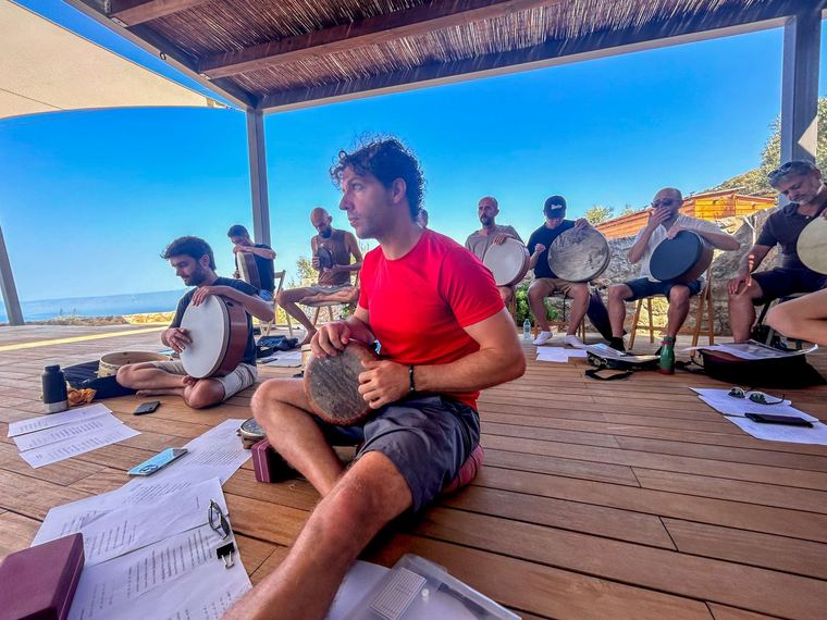 A circle of players on the deck above the sea