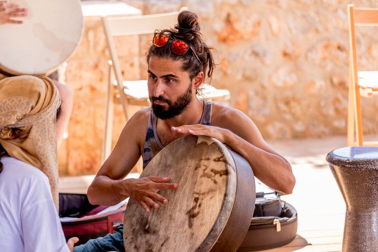 A student playing a frame drum