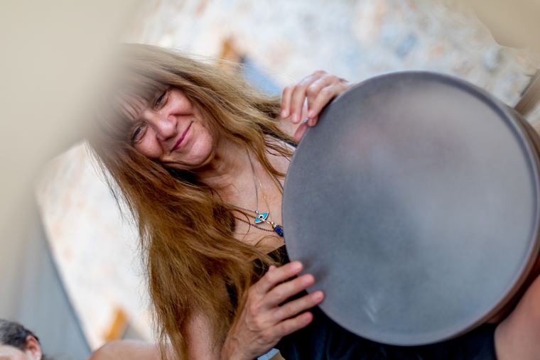 A student smiling over her frame drum