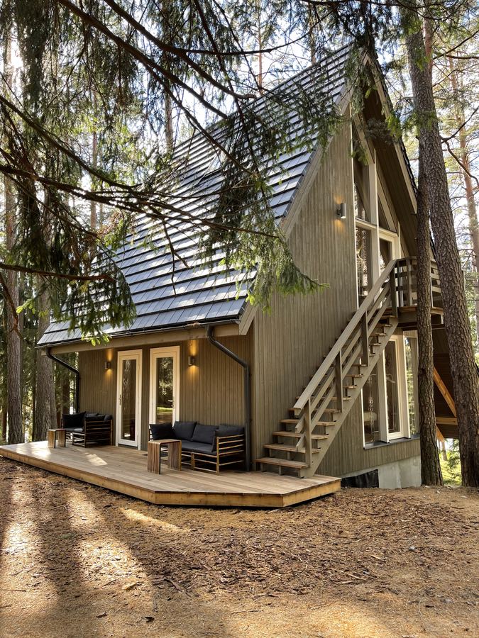 A wooden house with outside stairs among the pines