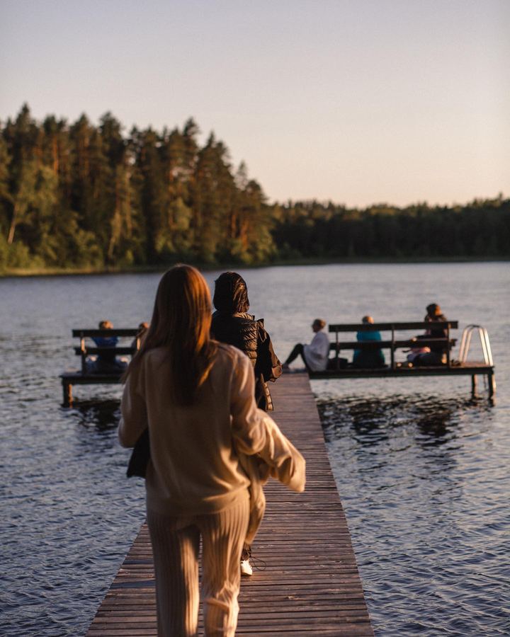 People walking out along the pier to the platform on the lake