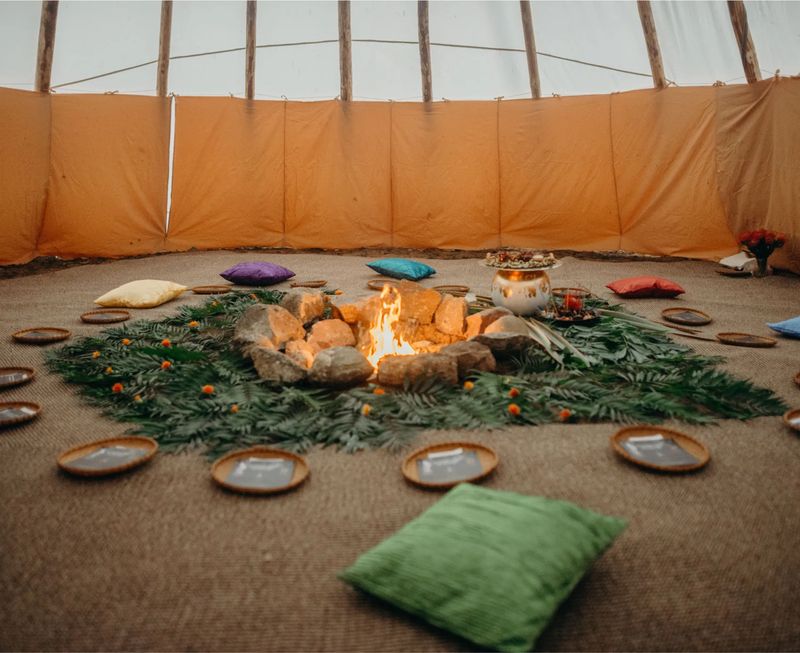Inside the tipi: cushions in a circle around the fire